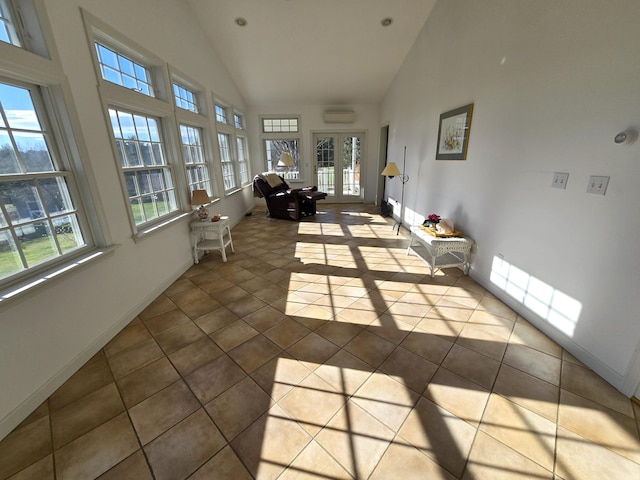 sunroom with lofted ceiling, a wall unit AC, and a healthy amount of sunlight