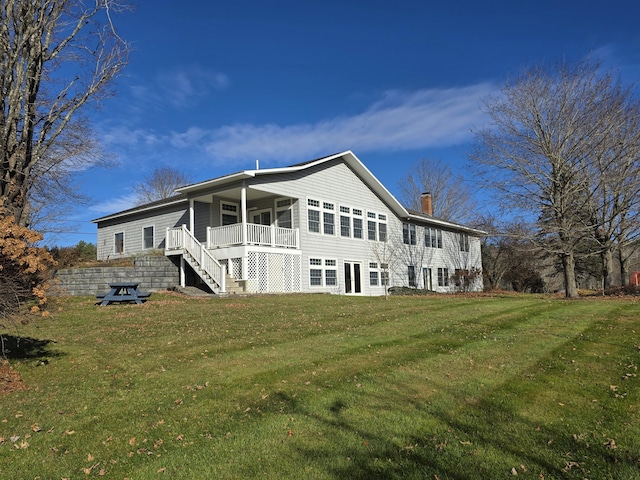 rear view of house featuring a lawn