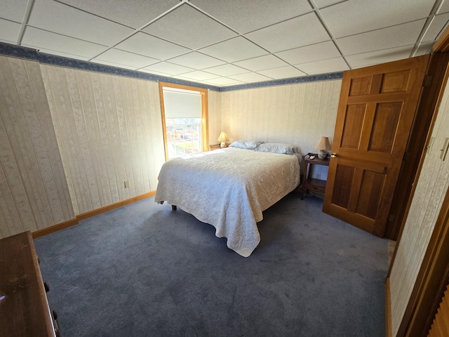 carpeted bedroom featuring a drop ceiling