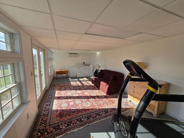 exercise room with a drop ceiling and separate washer and dryer