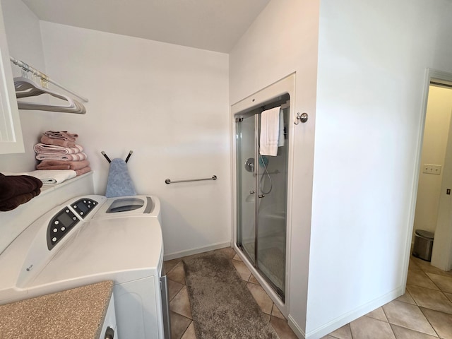 clothes washing area featuring washing machine and dryer and light tile patterned floors