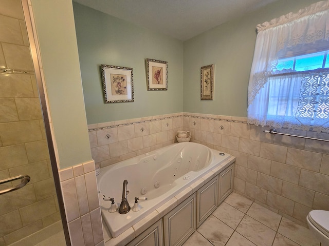 bathroom with tile walls, tile patterned flooring, a bathtub, and toilet