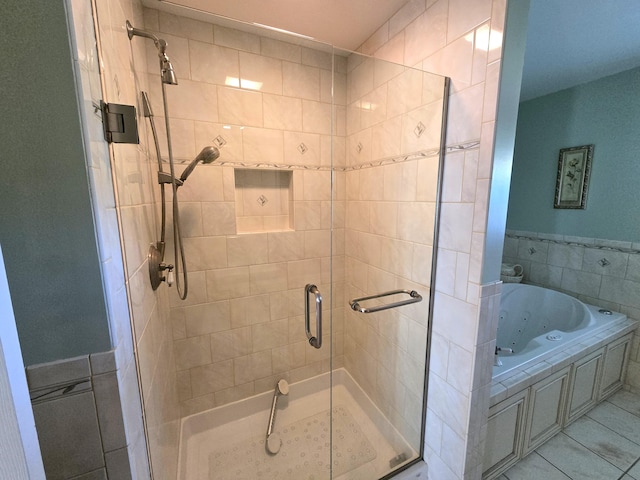 bathroom with tile patterned flooring, shower with separate bathtub, and tile walls