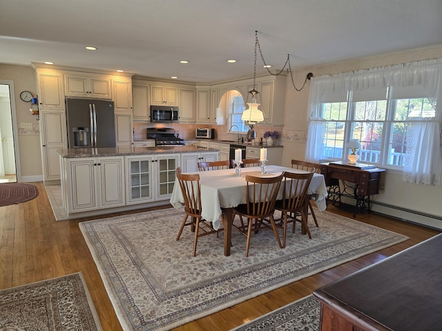 dining space with hardwood / wood-style floors and sink