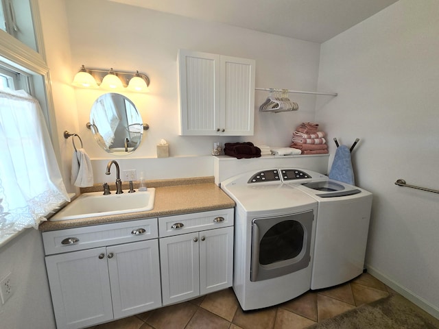 clothes washing area featuring washing machine and dryer, cabinets, sink, and tile patterned flooring