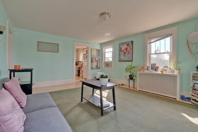 living room featuring cooling unit, radiator heating unit, and light colored carpet