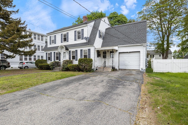 19 Harding St, Biddeford, ME 04005 - view of front facade with roof with shingles, an attached garage, asphalt driveway, a chimney, and a gambrel roof