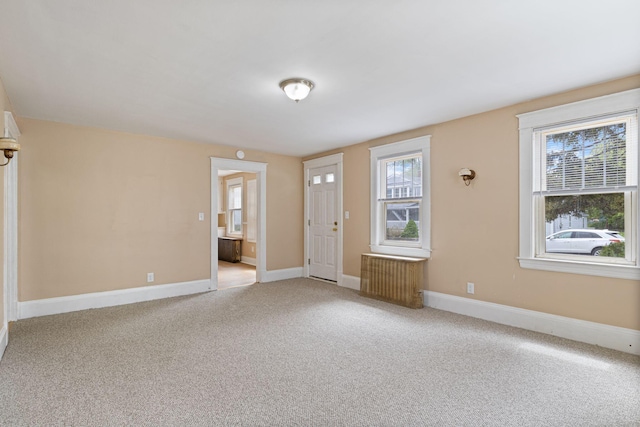 19 Harding St, Biddeford, ME 04005 - foyer with radiator heating unit, light colored carpet, and baseboards
