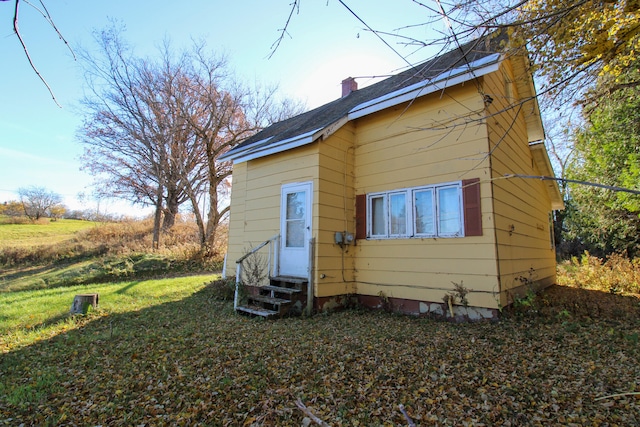 back of property featuring a lawn