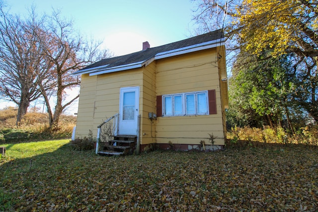 back of property featuring a lawn