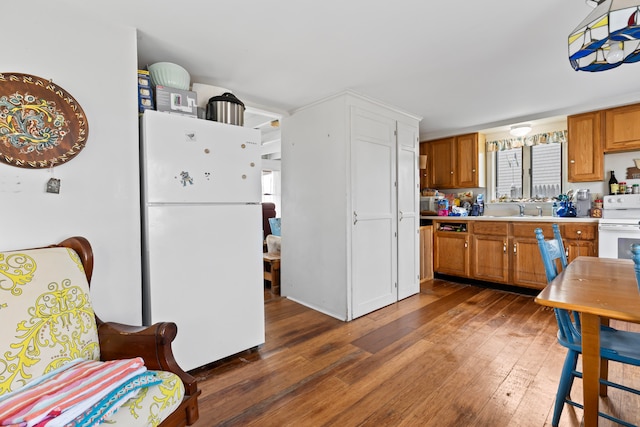 kitchen with sink, dark wood-type flooring, and white appliances