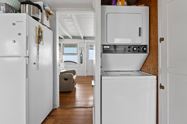 washroom featuring dark wood-type flooring and stacked washer and dryer