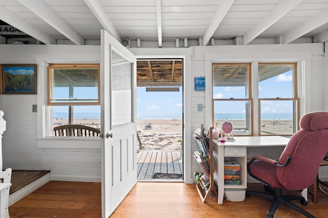 interior space with hardwood / wood-style flooring, a healthy amount of sunlight, and beamed ceiling