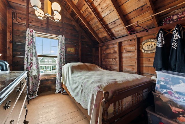 bedroom featuring vaulted ceiling, wood walls, light hardwood / wood-style flooring, and wood ceiling