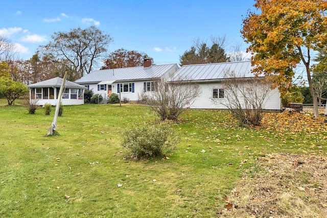 view of front of property with a sunroom and a front yard