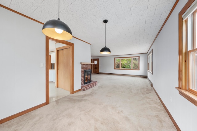 unfurnished living room with ornamental molding, a fireplace, and light carpet