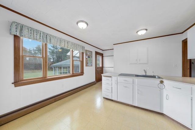 kitchen with white cabinetry, a baseboard radiator, sink, and plenty of natural light