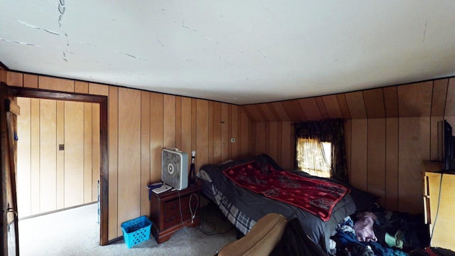 carpeted bedroom featuring wooden walls