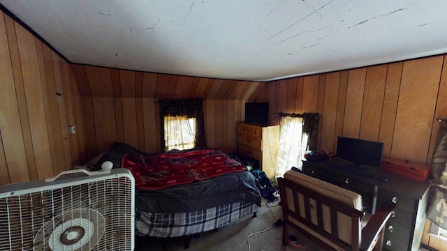 carpeted bedroom with lofted ceiling and wood walls