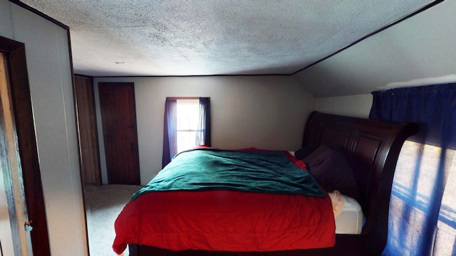 bedroom with carpet, a textured ceiling, and vaulted ceiling