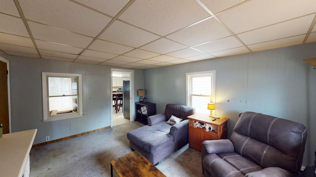 carpeted living room featuring a paneled ceiling