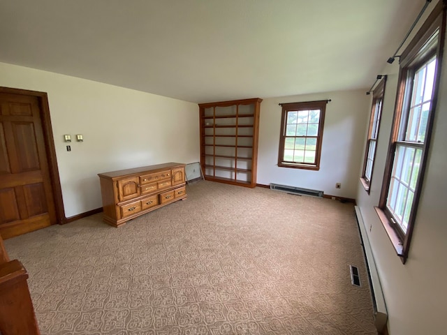 carpeted spare room featuring a baseboard radiator