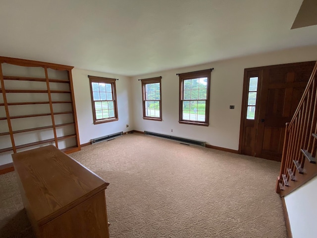 unfurnished living room with baseboard heating and light carpet