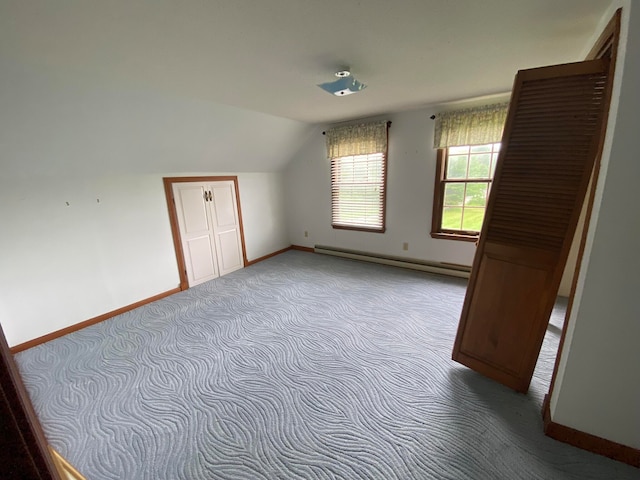 bonus room with lofted ceiling, a baseboard heating unit, and light colored carpet