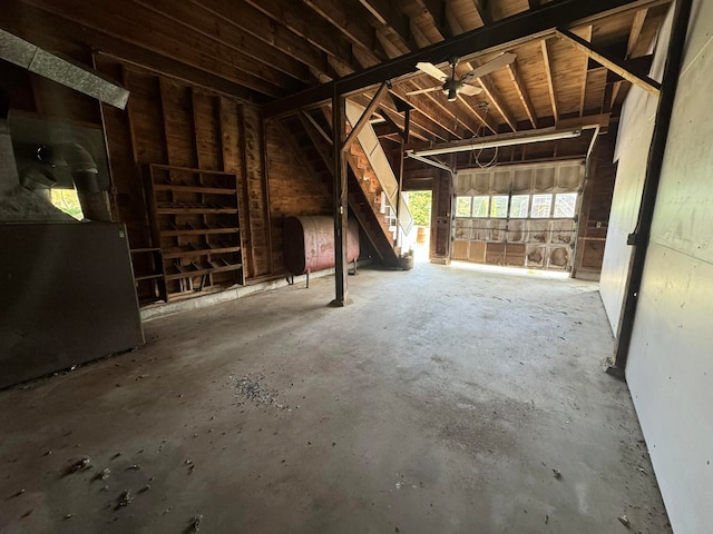 miscellaneous room featuring ceiling fan, heating unit, and concrete flooring