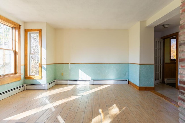 unfurnished room featuring light wood-type flooring and a baseboard radiator