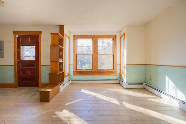 interior space featuring electric panel, light hardwood / wood-style floors, and a baseboard heating unit