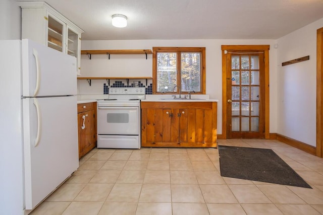 kitchen featuring sink, light tile patterned flooring, and white appliances