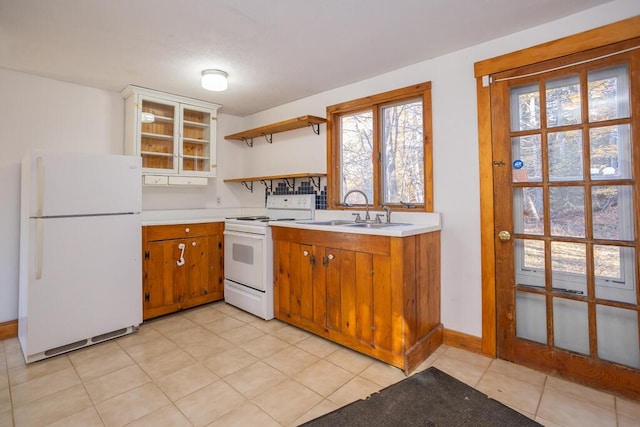 kitchen featuring sink, light tile patterned floors, and white appliances