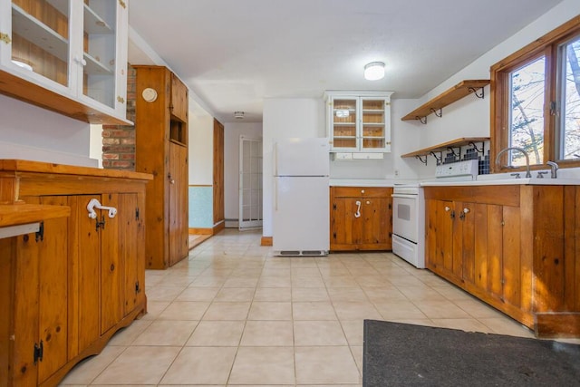 kitchen featuring white appliances, sink, and light tile patterned floors