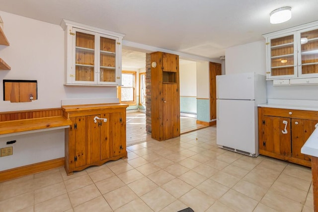 kitchen featuring white fridge, light tile patterned flooring, and a baseboard heating unit