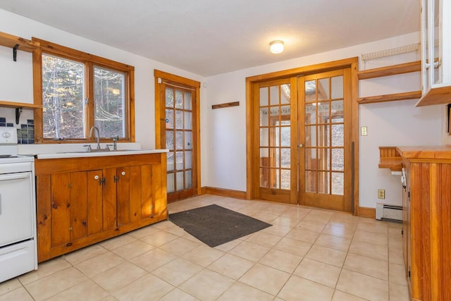 interior space with french doors, sink, baseboard heating, white range, and light tile patterned flooring