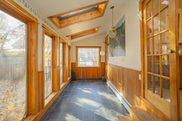 sunroom / solarium with a baseboard radiator and vaulted ceiling with skylight