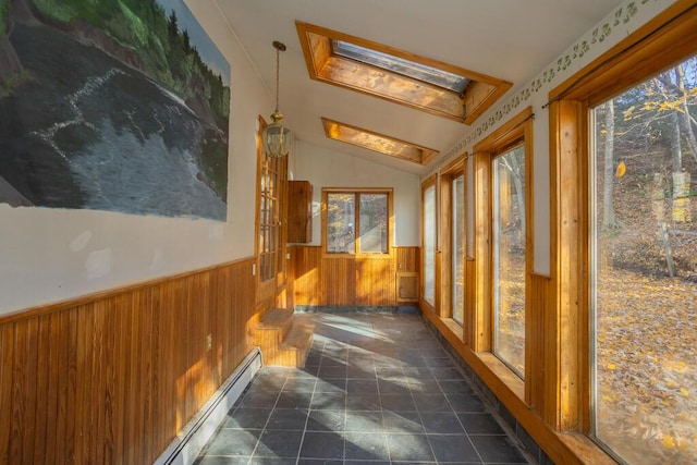 corridor featuring lofted ceiling with skylight, a healthy amount of sunlight, and wood walls