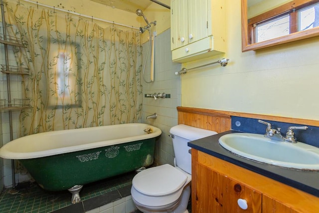 bathroom featuring tile patterned flooring, a washtub, toilet, and vanity