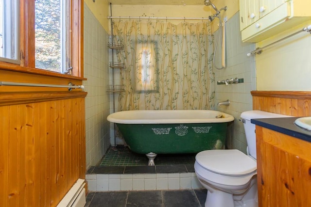 bathroom featuring a washtub, vanity, tile walls, tile patterned flooring, and toilet