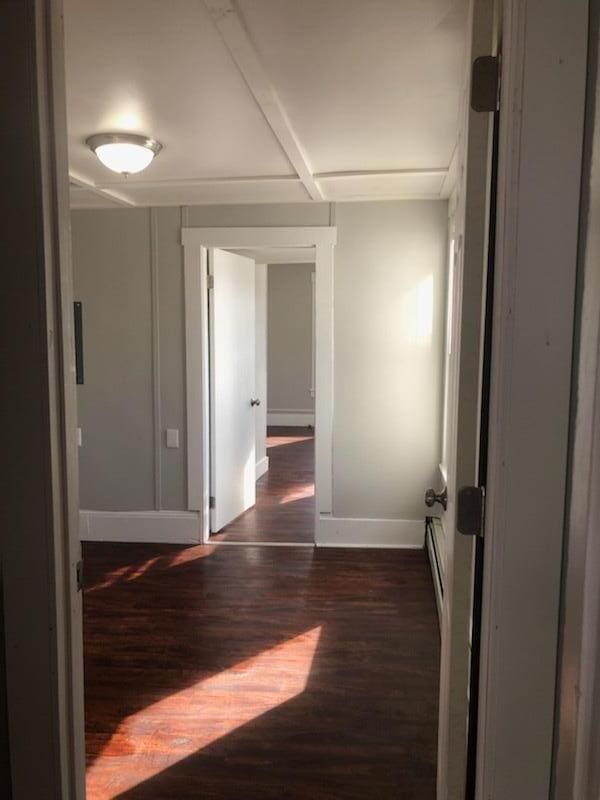 unfurnished room with dark wood-type flooring