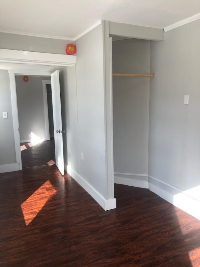 interior space with a closet, ornamental molding, and dark hardwood / wood-style flooring