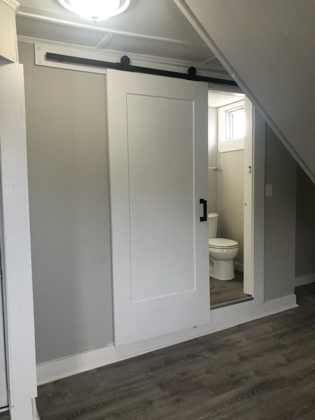 interior space with a barn door and dark wood-type flooring