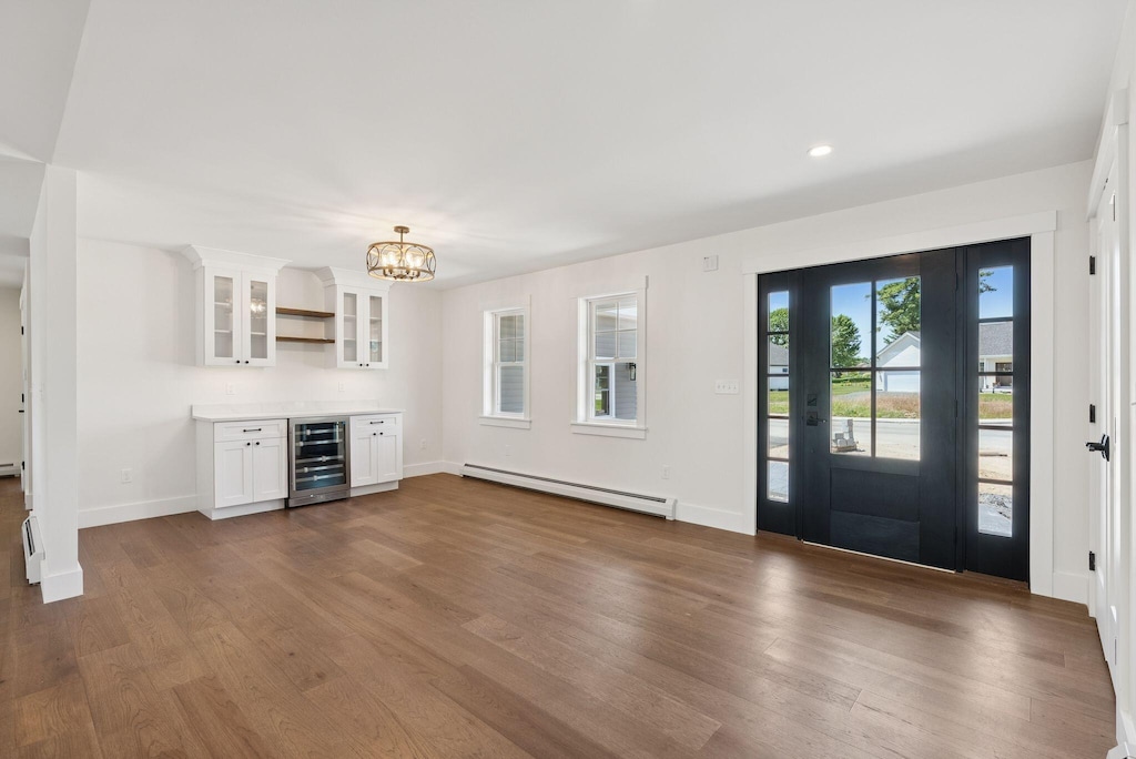 25 Magnolia Dr, Old Orchard Beach, ME 04064 - entryway with baseboard heating, wine cooler, dark wood-style floors, a chandelier, and recessed lighting