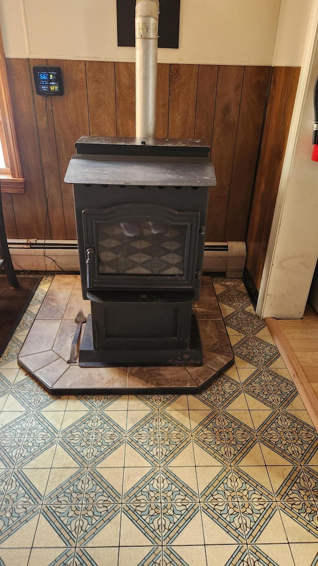 details with a wood stove, wood walls, and baseboard heating