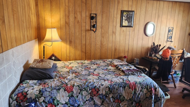 bedroom featuring dark hardwood / wood-style flooring, tile walls, and wood walls