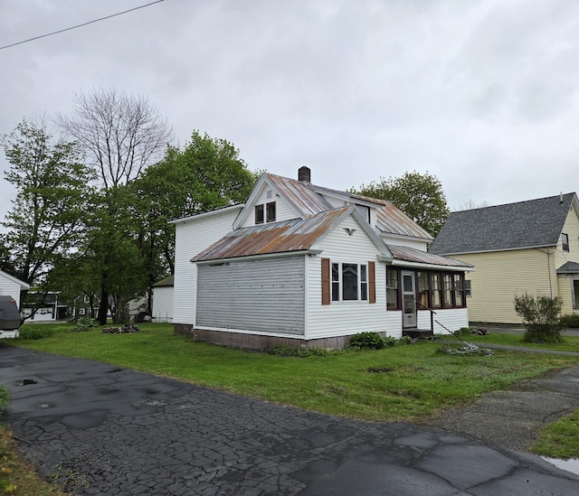 185 Knox St, Millinocket, ME 04462 - view of side of property with a sunroom, a chimney, metal roof, and a lawn