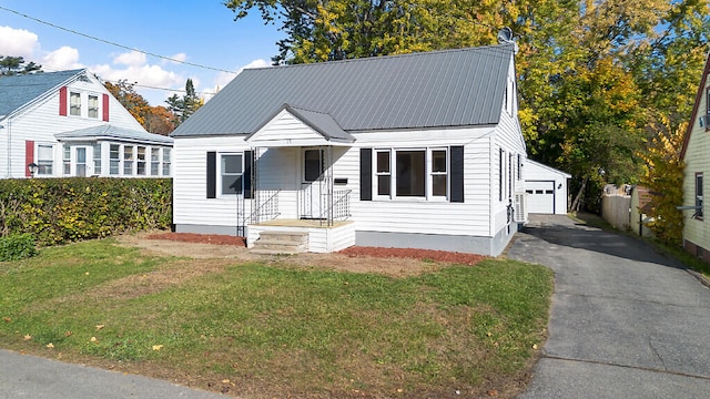 view of front of property featuring a garage, a front lawn, and an outbuilding