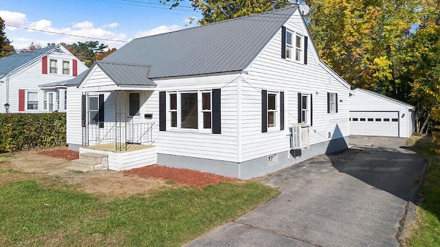 cape cod-style house featuring a front yard, an outbuilding, and a garage