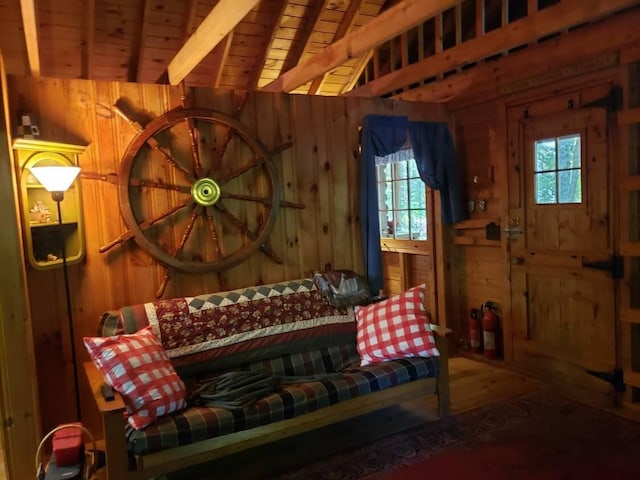 sitting room featuring lofted ceiling with beams, wooden ceiling, wood-type flooring, and wood walls